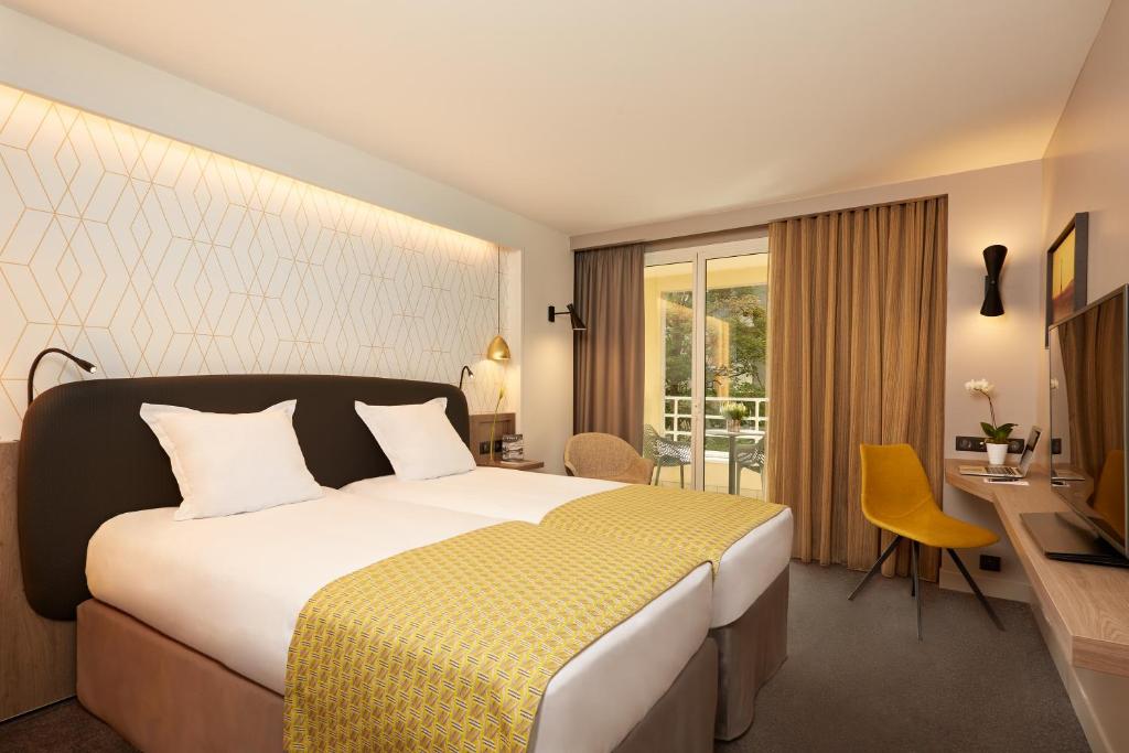巴黎奥特易图尔埃菲尔酒店的酒店客房配有一张床、一张书桌和一台电视。