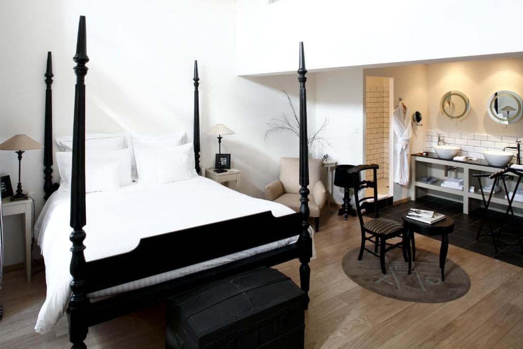 圣阿姆贝尔维尤天堂客栈的卧室配有黑白床和书桌。