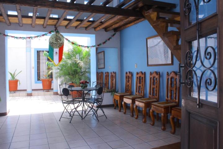 瓦哈卡市HOTEL NIUT-JA的一间配备有桌椅和蓝色墙壁的餐厅