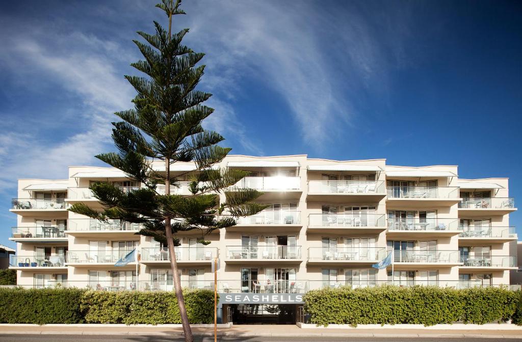 珀斯海贝士嘉堡酒店的一座建筑前的棕榈树