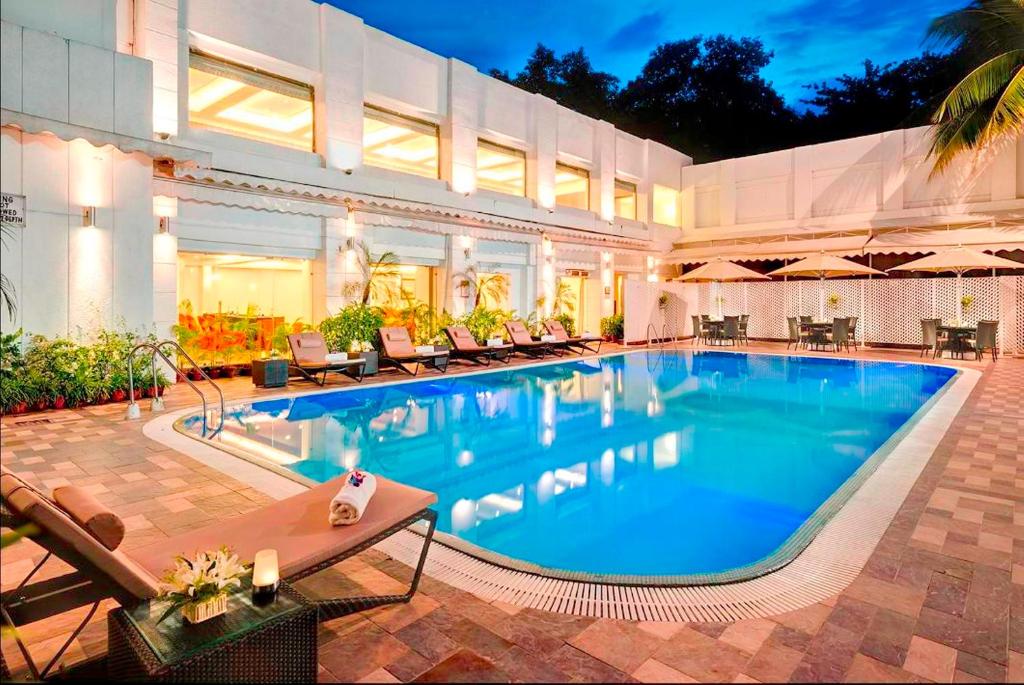 加尔各答印度加尔各答斯坦国际酒店的一座带椅子的大型游泳池和一座建筑