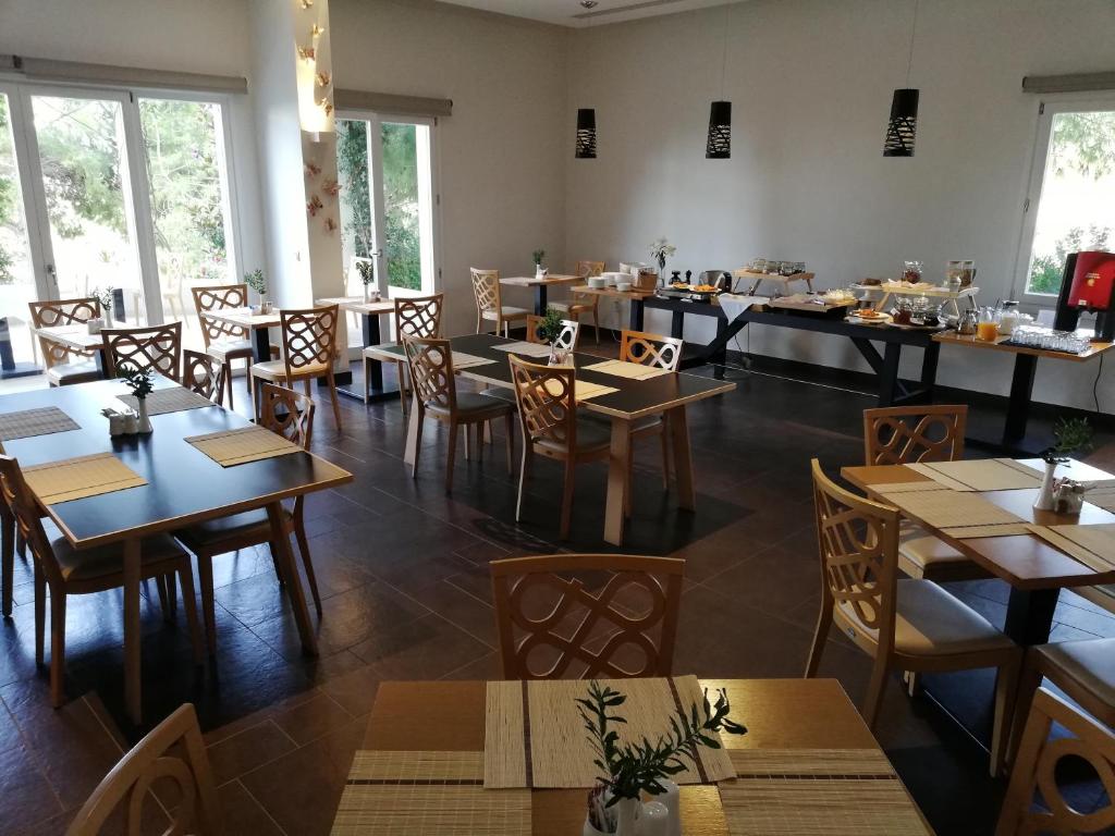 卡塔科隆奥里兹翁特美景酒店的餐厅设有木桌、椅子和窗户。