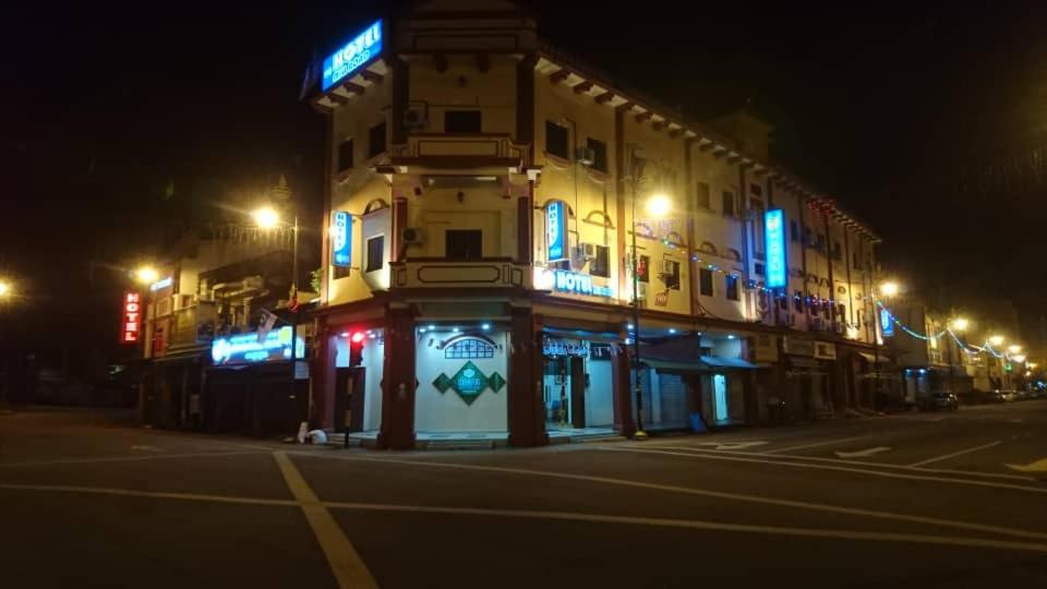 马六甲Hotel Mill Road的街上的一座建筑,晚上有蓝色的灯光