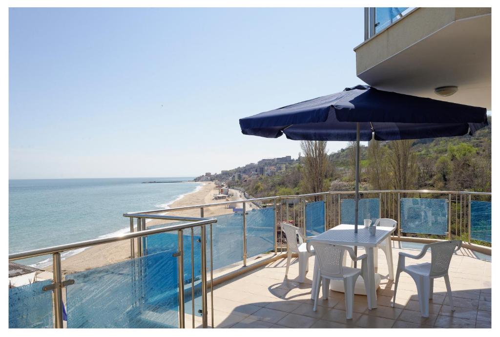 金沙Kabakum Apartments的一个带桌椅和海滩的阳台