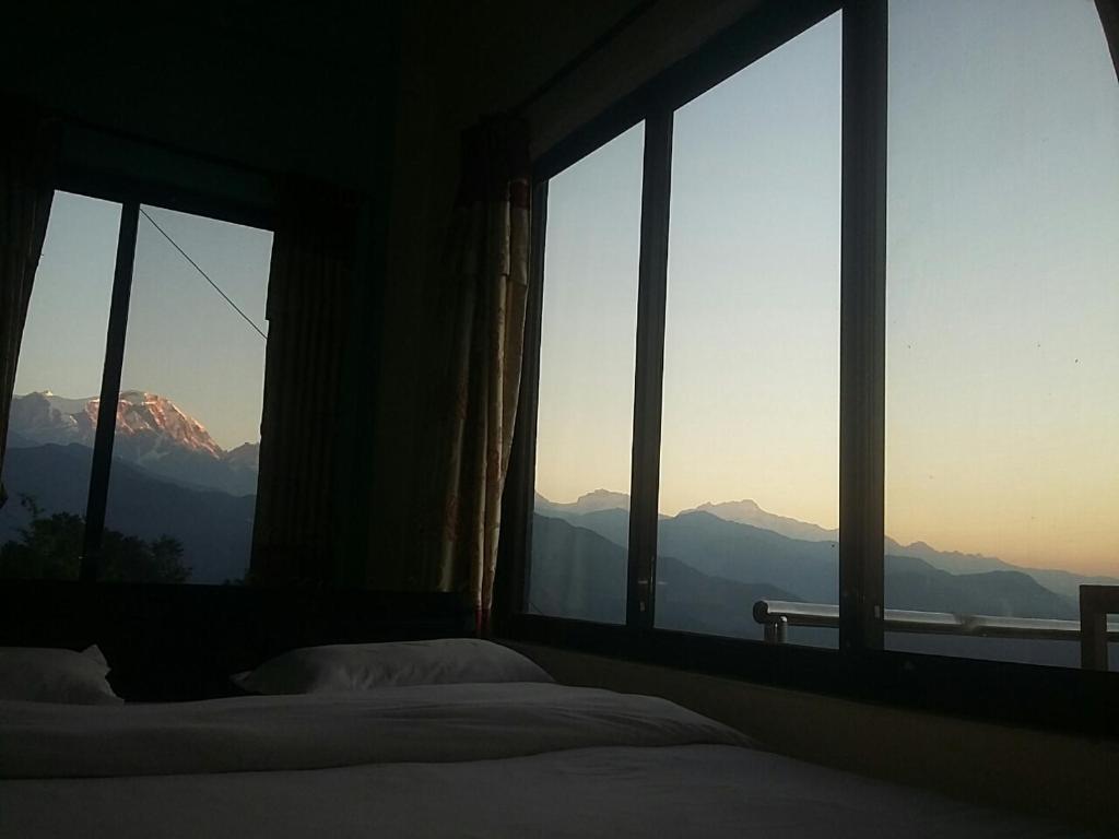 博卡拉Himalayan crown lodge的一间卧室设有山景窗户。