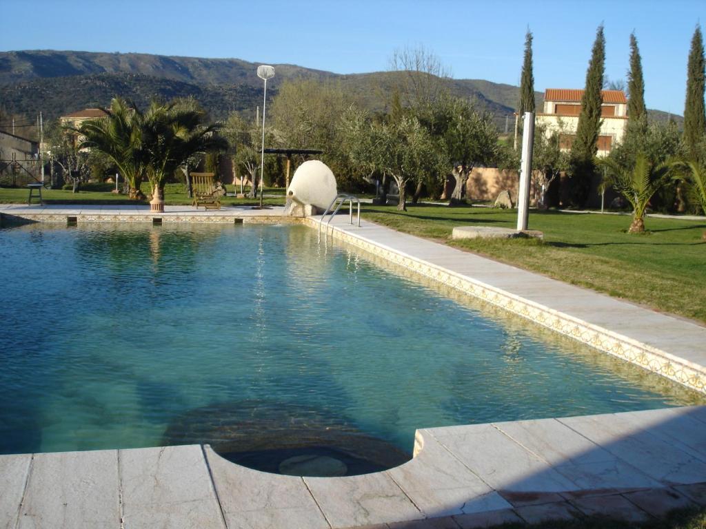 卡米诺新村特瑞斯门提拉丝旅馆的一座游泳池,位于树木和山脉的公园内