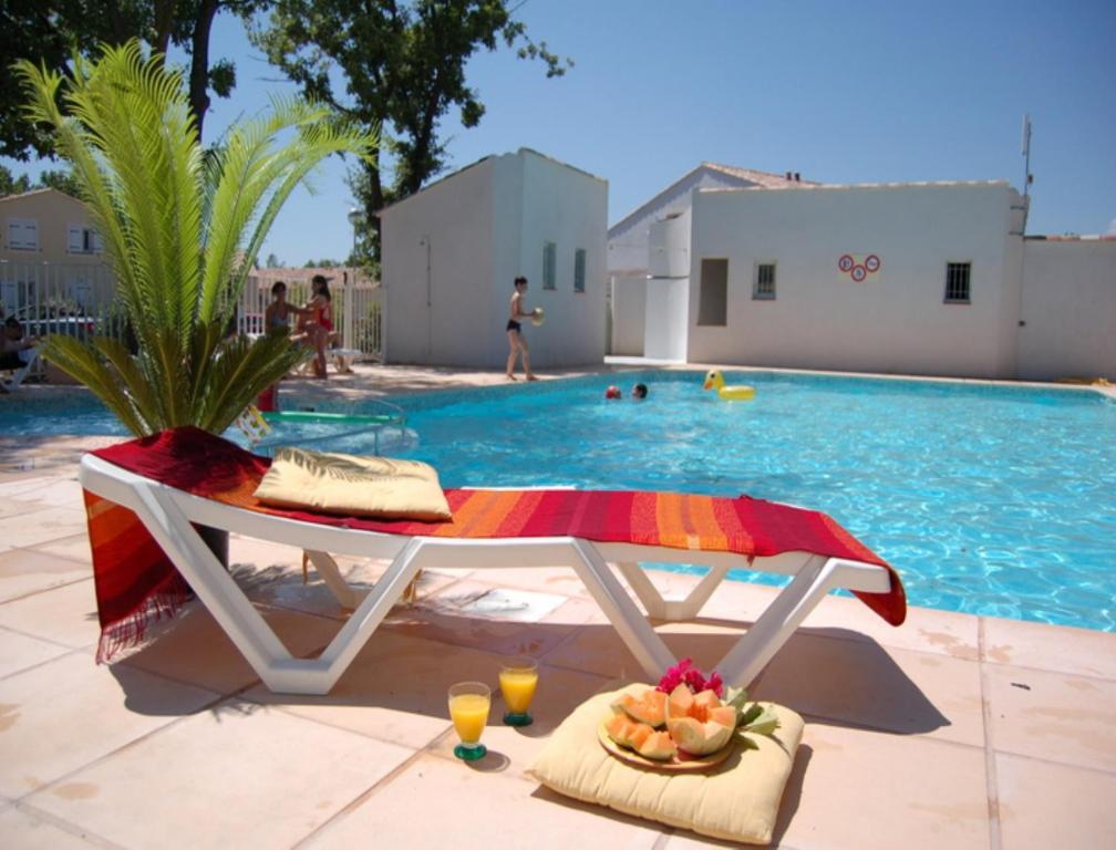 图雷特Vacancéole - Les Bastides de Fayence的一个带桌子的游泳池,备有饮料和一碗水果