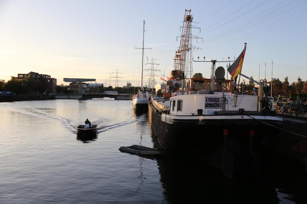 汉堡Schiffshotel "Schlafen im Hafen"的两艘船停靠在码头旁边的水中