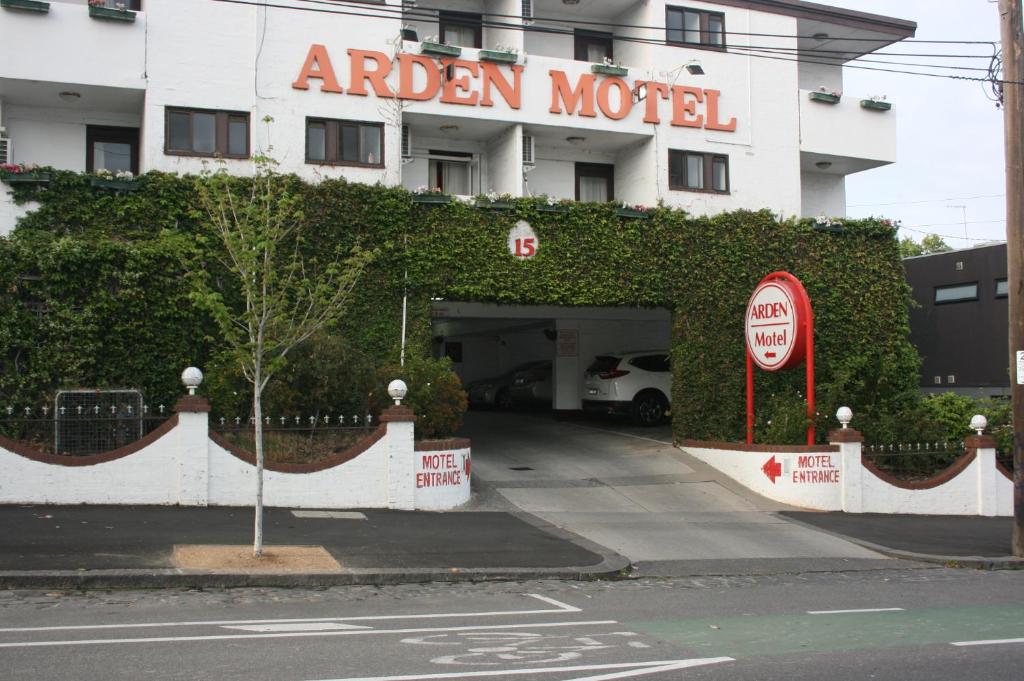 墨尔本Arden Motel的一座带车库的建筑,上面有酒店标志