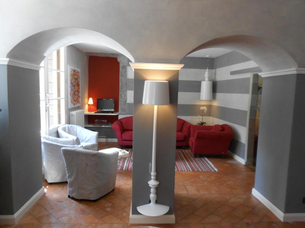 坎诺比奥卡萨阿瑞泽欧酒店的客厅配有落地灯和红色椅子