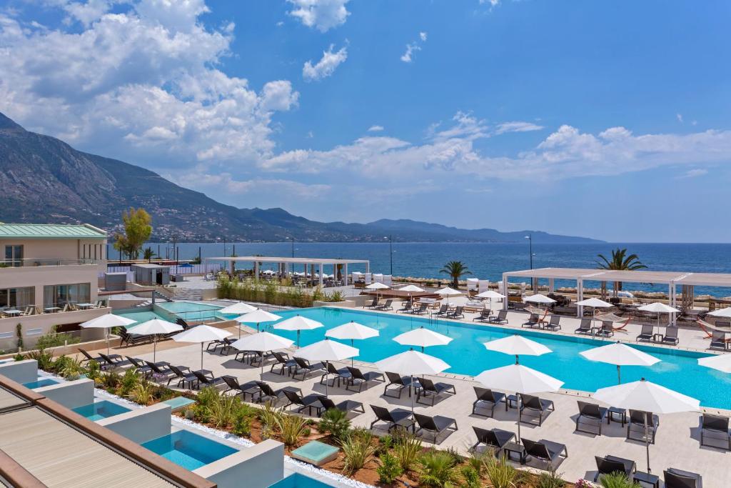 卡拉马塔Horizon Blu Boutique Hotel的享有带椅子和遮阳伞的度假村的游泳池景致