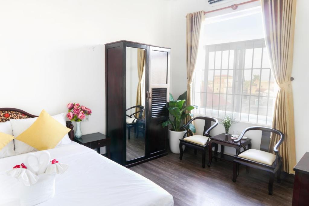 顺化Hue Royal Hotel的卧室配有白色的床和镜子