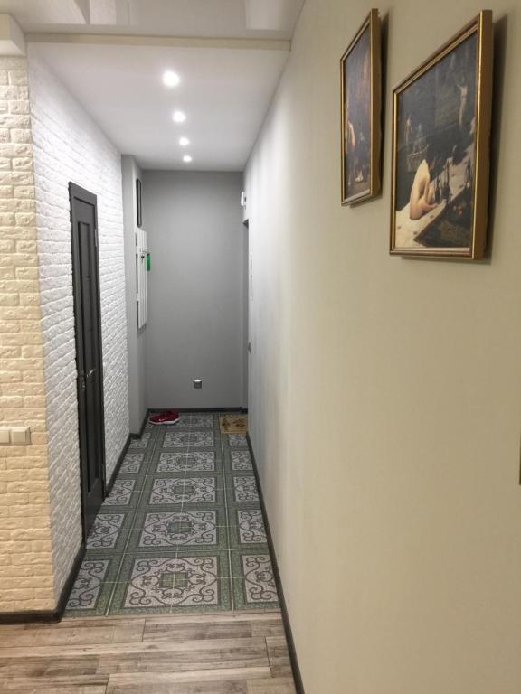 切尔尼戈夫Двухкімнатна студія的走廊上设有瓷砖地板和墙上的两张照片