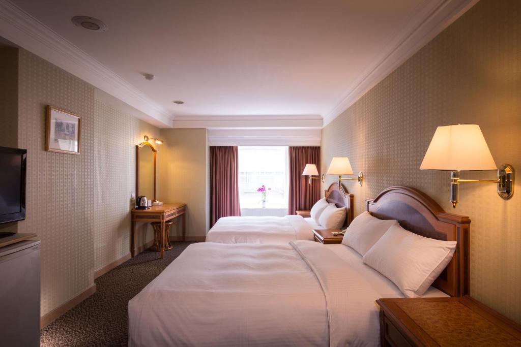 台北洛碁大饭店花华分馆的酒店客房设有两张床和窗户。