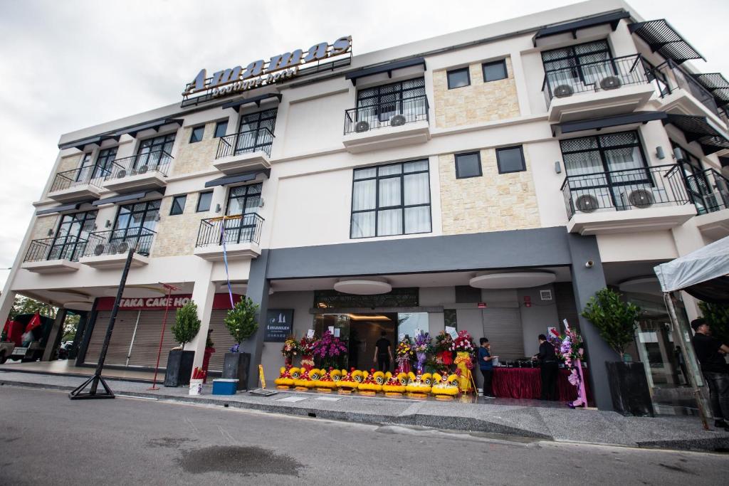 古晋Amamas Boutique Hotel Kuching的街上有一间商店的大白色建筑
