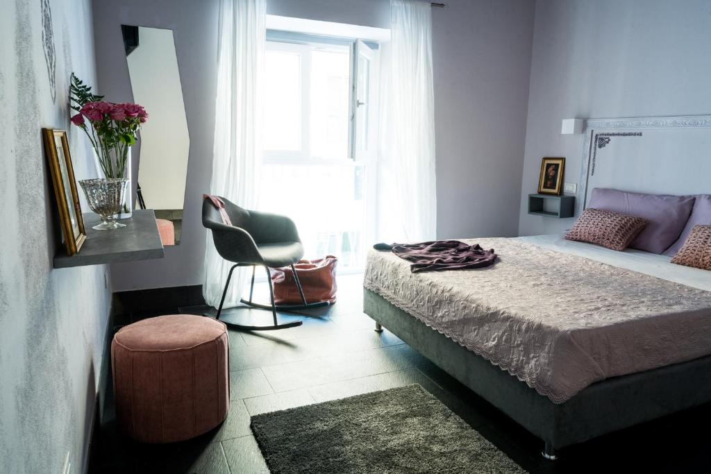 斯培西亚5 Terre Inn Affittacamere的卧室配有床、椅子和窗户。