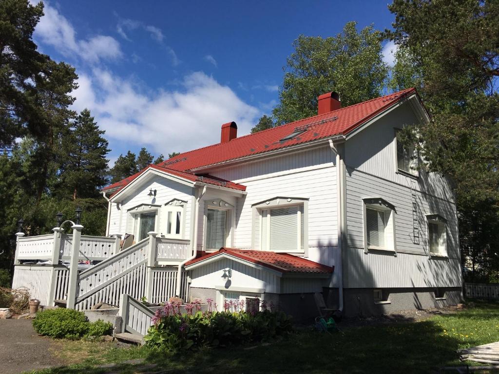奥卢Yrjänäntie Home Apartment的一座红色屋顶的白色旧房子
