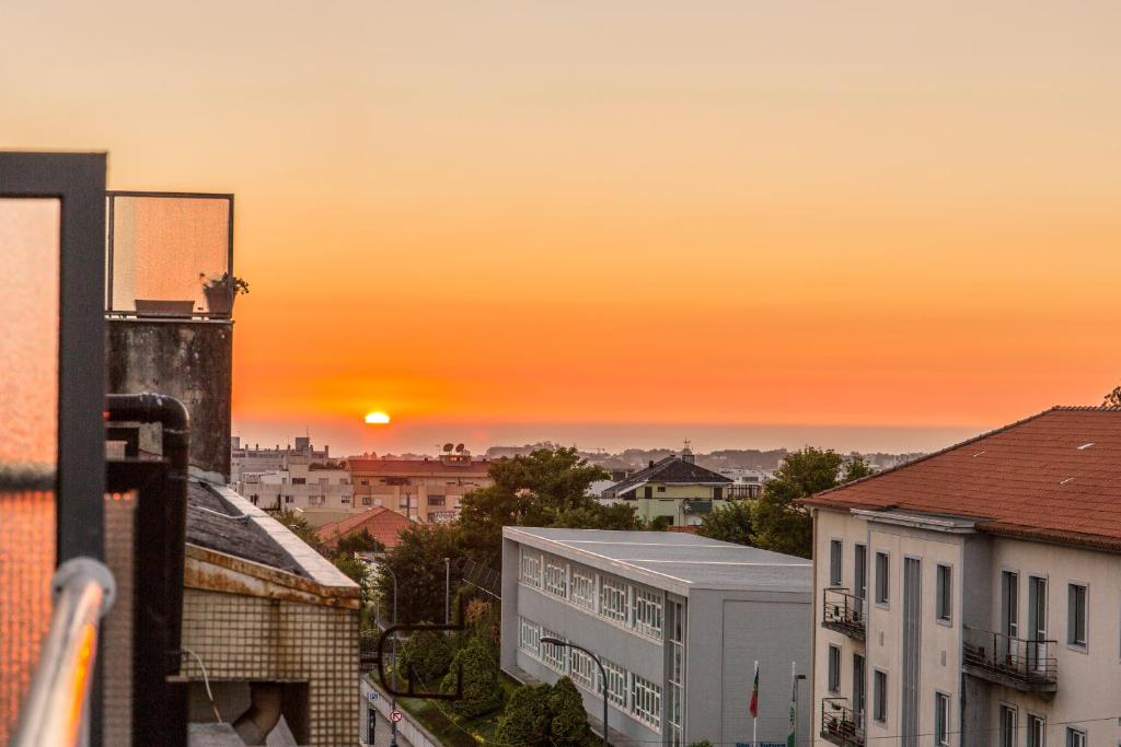 波尔图Sunset Relaxing Apt with terrace, parking & bikes的从大楼欣赏日落美景