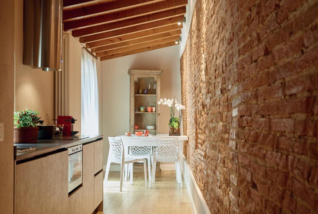 佛罗伦萨Pergola35的厨房配有白色桌子和砖墙