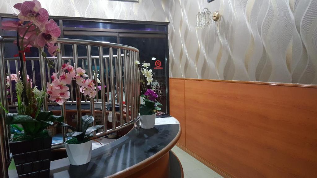 TuaranNew Orchid Hotel Tuaran的花瓶在柜台上的房间