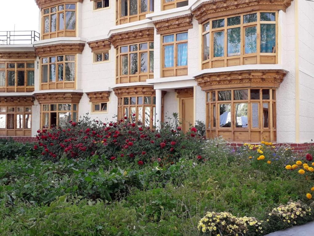 列城Zee Guest House的前方有窗户和鲜花的建筑