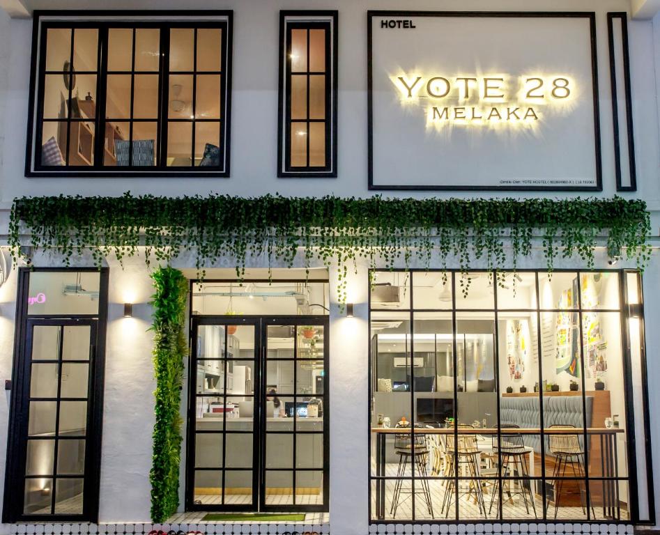 马六甲Yote 28的商店前方设有窗户和常春藤