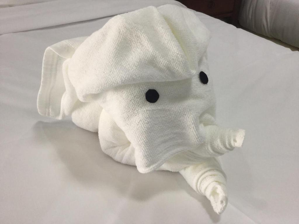 清莱SABUN-NGA HOSTEL的床上铺着大象的白色毛巾