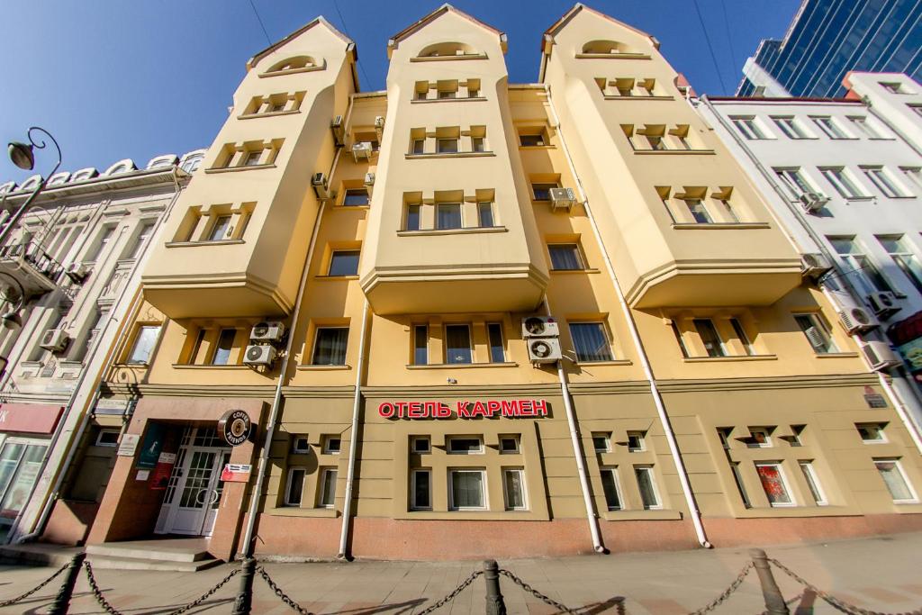 符拉迪沃斯托克卡门旅馆的黄色的建筑,上面有红色的标志