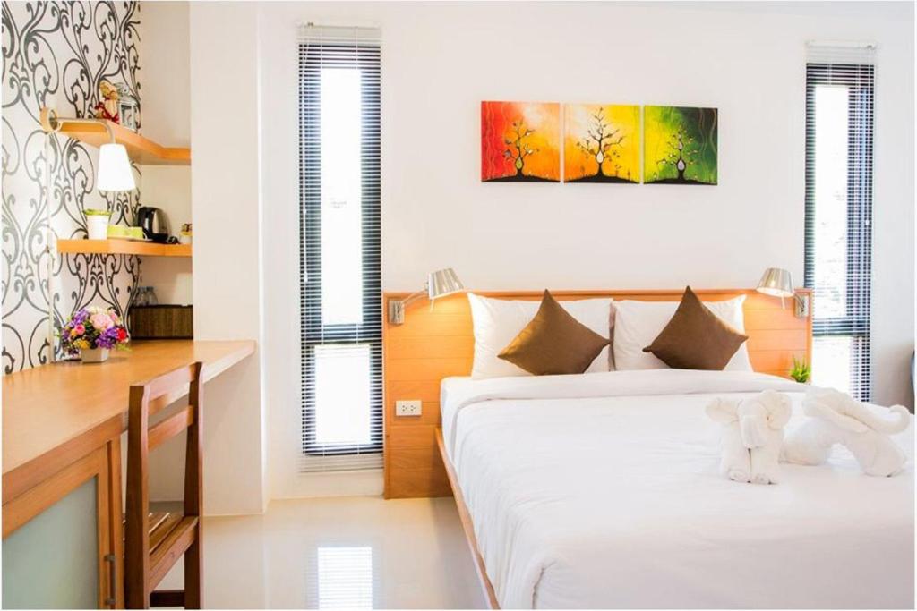 Ban Nua Khlong帕尔马里精品酒店的卧室配有一张床和一张桌子,上面有一只白色填充动物