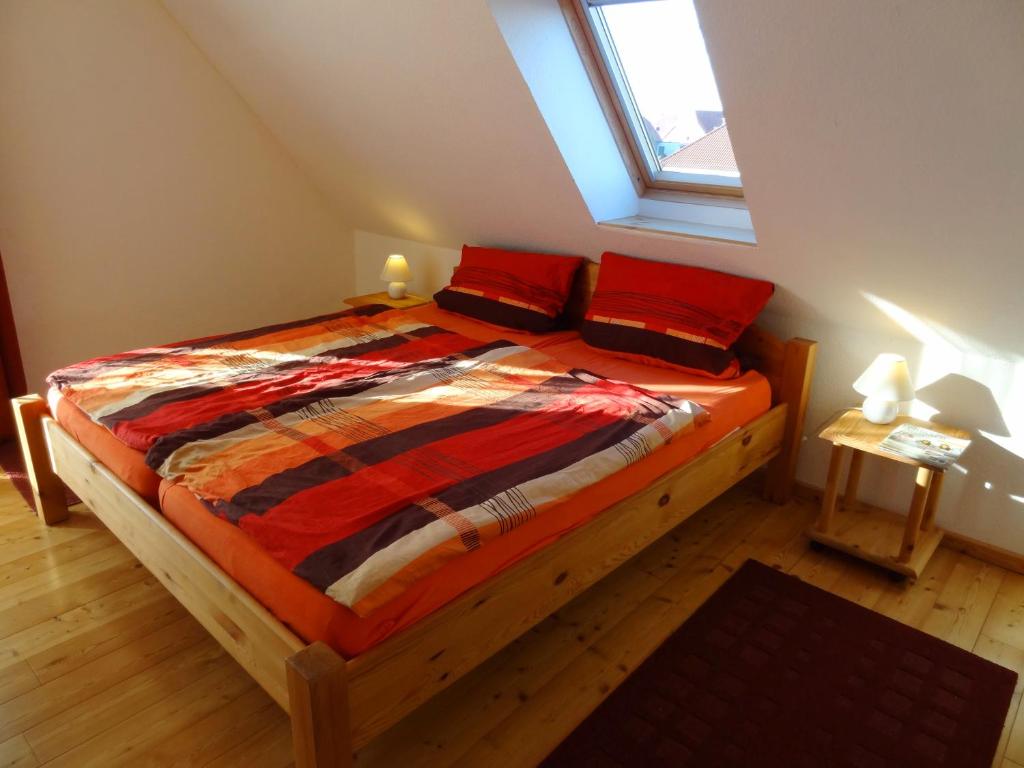 费马恩Ferienwohnungen Hass - Haus 10的一间卧室配有一张带红色枕头的床和一扇窗户