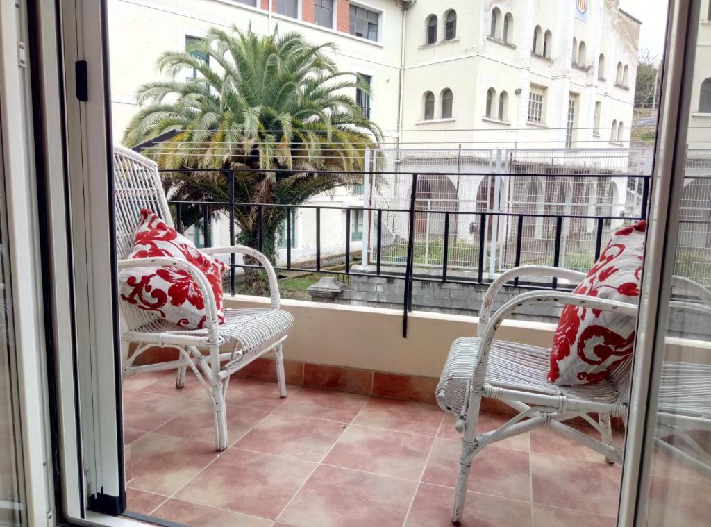 雷凯蒂奥Apartamento centrico en Lekeitio, playa y puerto的两把椅子坐在带窗户的阳台