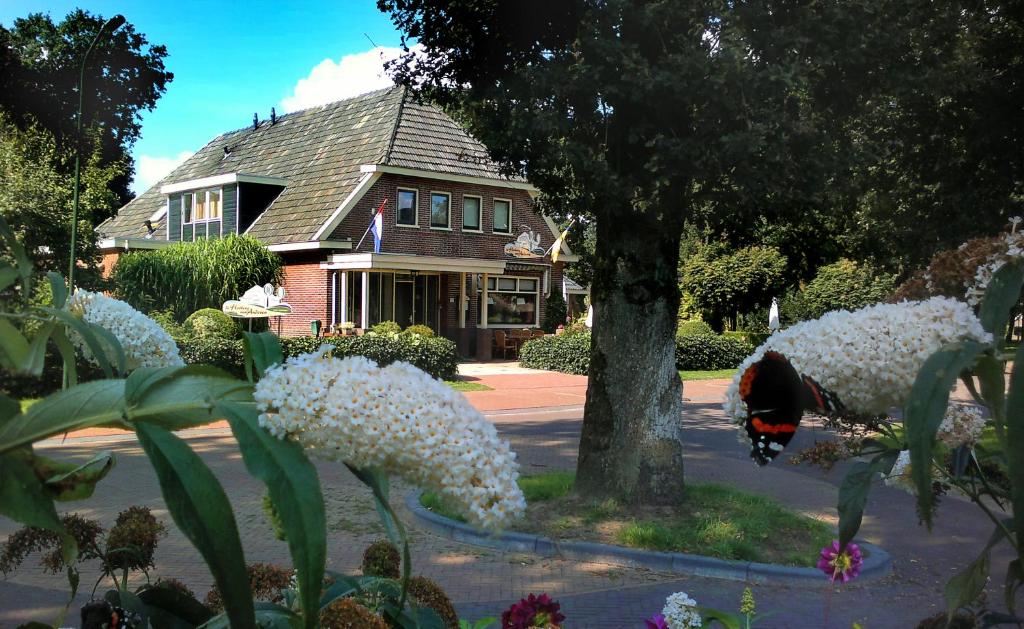 Anderen德和勃艮万安得润酒店的树前有白色花的房子
