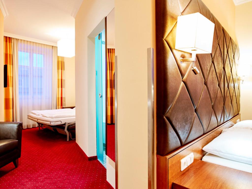 萨尔茨堡达斯格伦博斯特酒店赛科尼公寓式酒店的酒店客房,设有两张床,铺有红地毯。