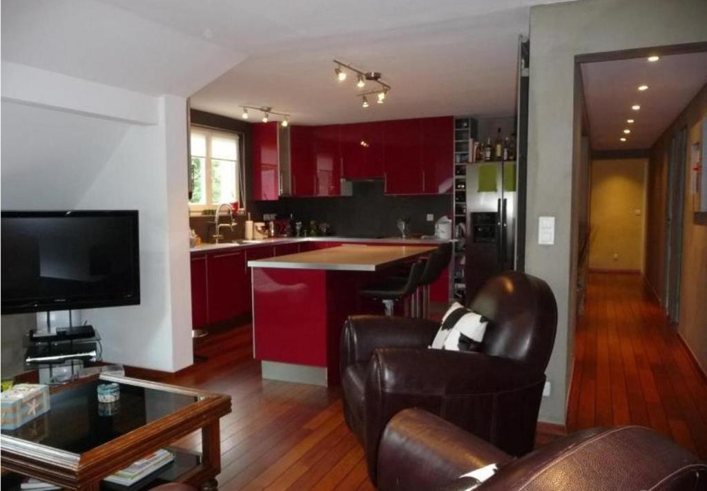 科特雷PETIT YATOU APPART'的厨房配有红色橱柜和皮椅