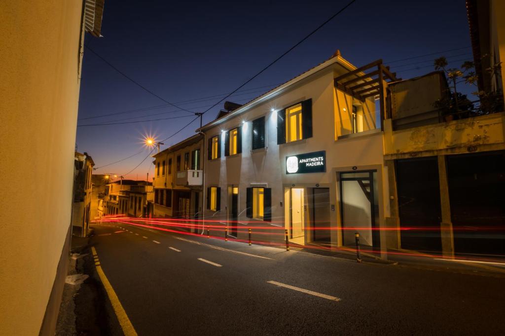 丰沙尔Apartments Madeira City Center的一条空荡荡的城市街道,晚上有一座建筑