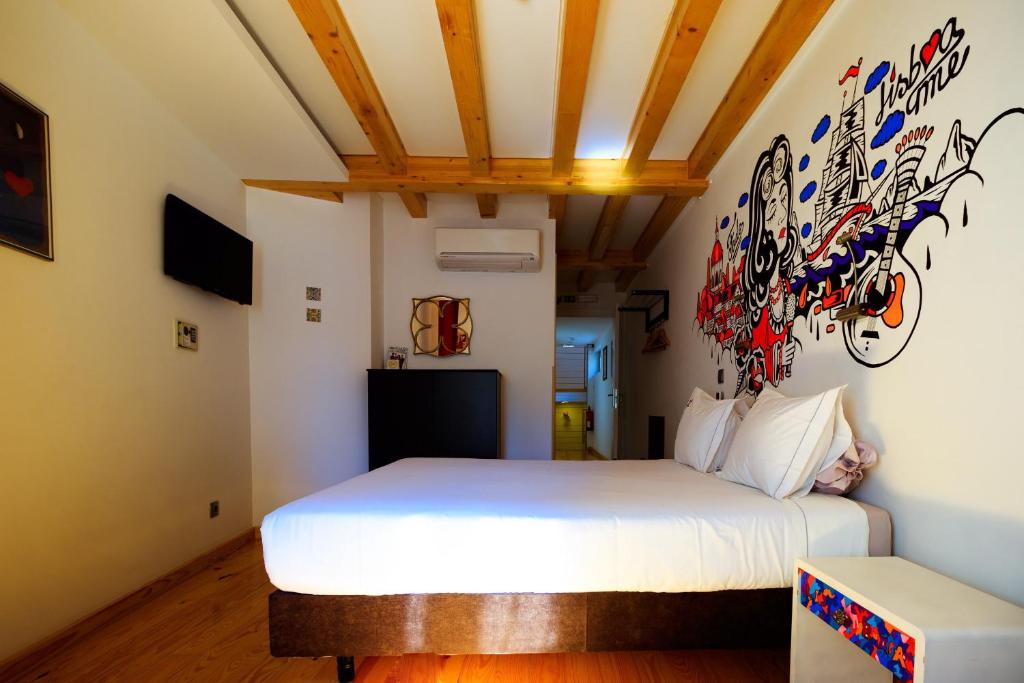 里斯本House Petit Lusa的一间卧室配有一张床和涂有涂鸦的墙壁
