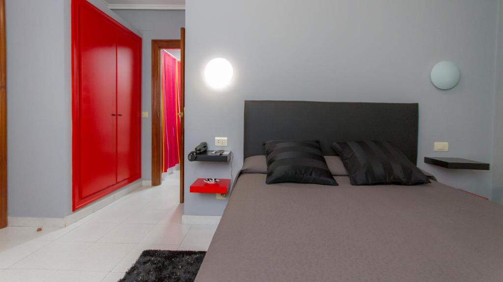 乌迪亚莱斯堡海滨休闲旅馆的一间卧室设有一张大床和红色的门