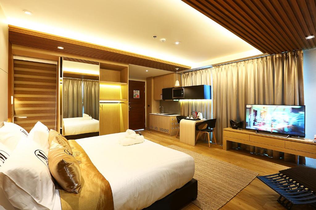 宋卡Montana Hotel Songkhla的配有一张床和一台平面电视的酒店客房