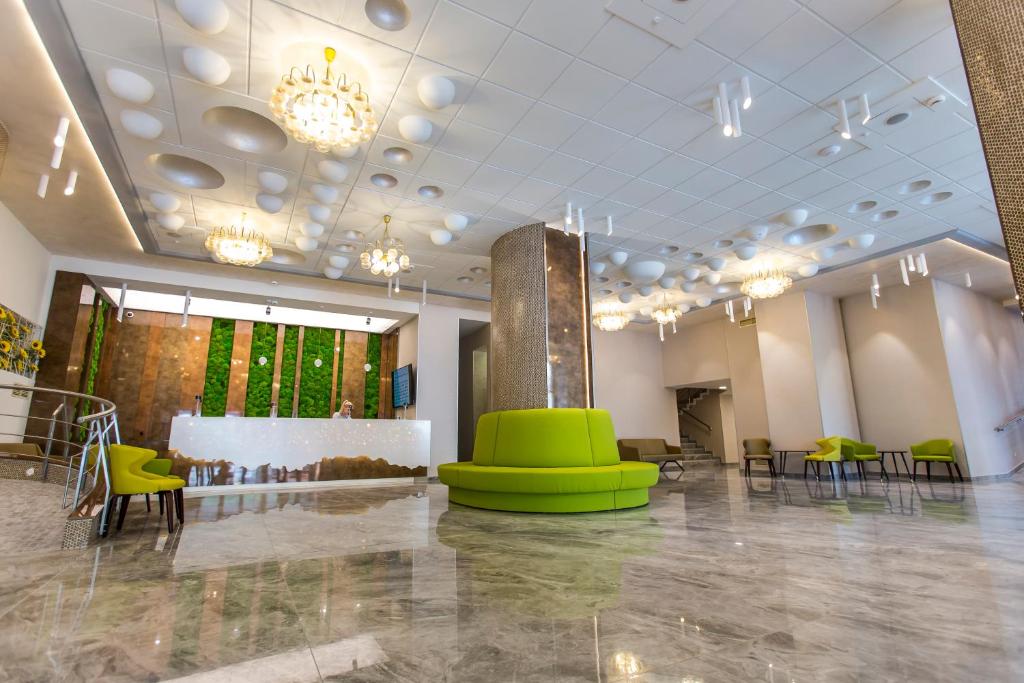 百乐·奥拉内斯蒂Hotel Olanesti & Spa Medical的大房间设有绿色的椅子、桌子和吊灯
