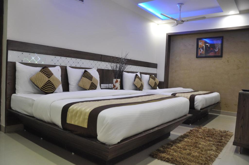 新德里维尔Dx酒店住处的一间卧室,在房间内配有两张大床