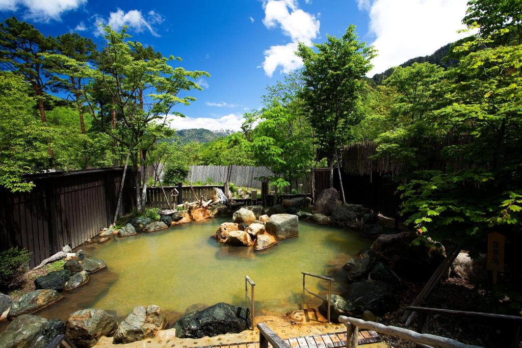 高山Miyama Ouan Kyoritsu Resort的河中一片带岩石的水池