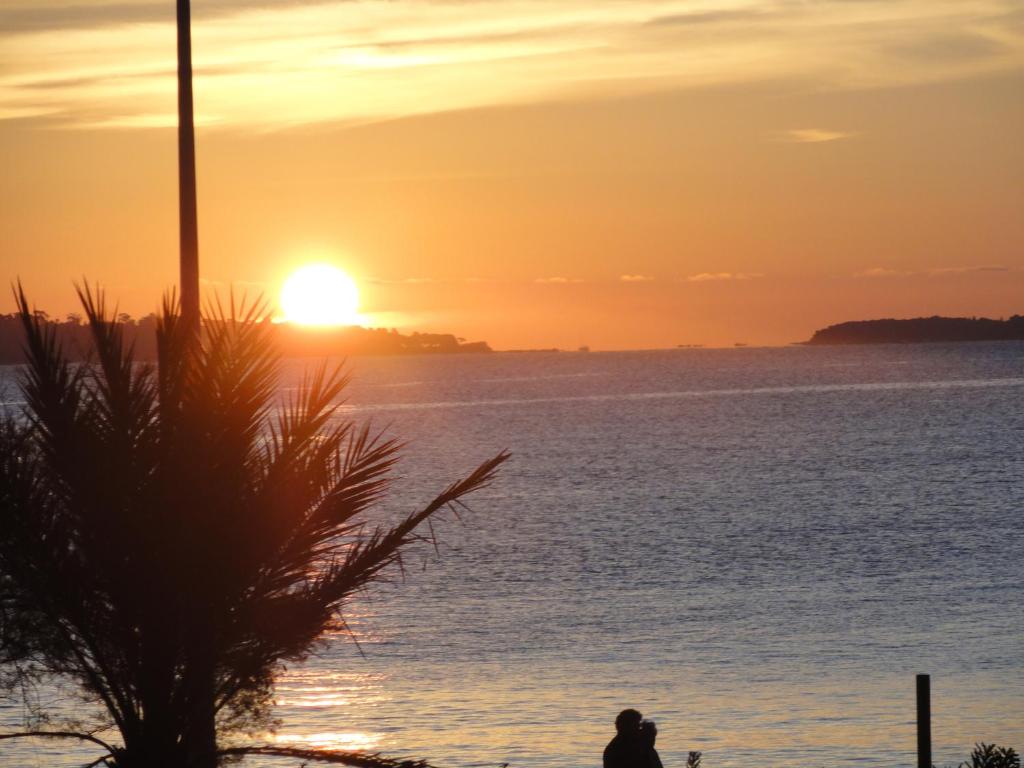戛纳戛纳特拉瑟海滨及海景公寓 的日落时站在海洋前的人
