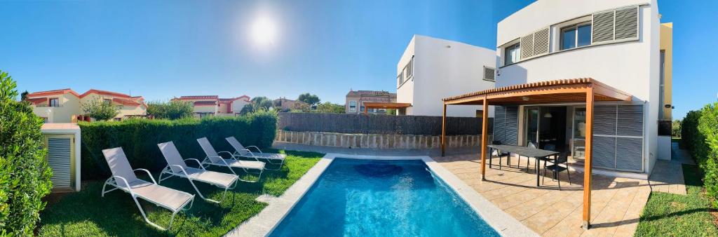 卡兰博希Villa Lauvic的后院设有游泳池、椅子和房屋