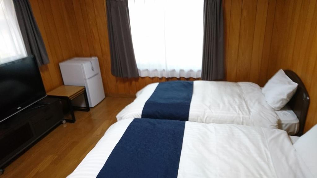 桑名市Minpaku Nagashima room5 / Vacation STAY 1034的酒店客房设有两张床和一台平面电视。