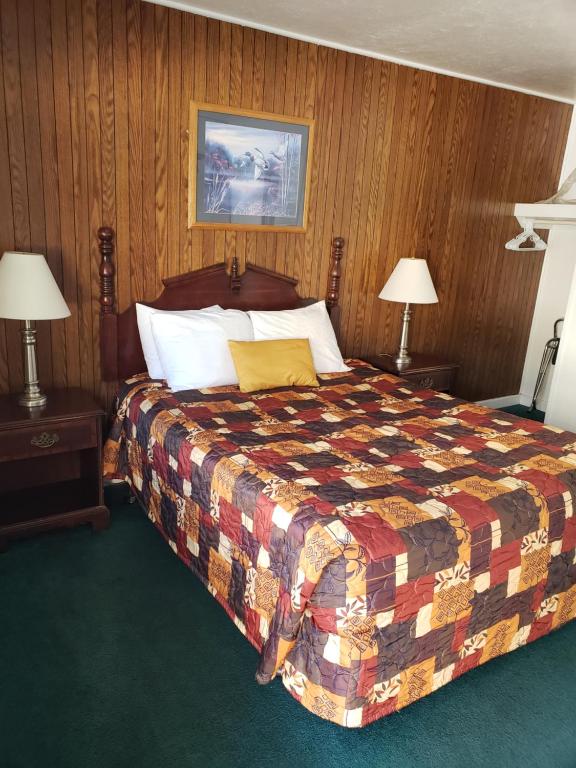 马里波萨马瑟洛德旅舍的一间卧室配有一张带五颜六色被子和两盏灯的床。