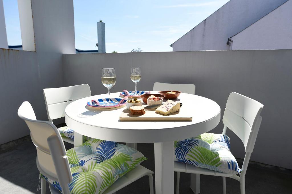 巴利卡斯尔Causeway Coast Apartments Kyla Marine的白色的桌椅和酒杯