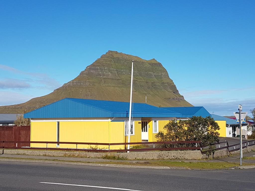 格仑达积图Sæból/Ocean Lair的一座黄色的建筑,背景是一座山