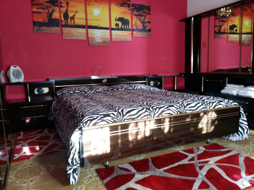 兰达佐La Romantica的一间卧室配有一张粉红色墙壁的床