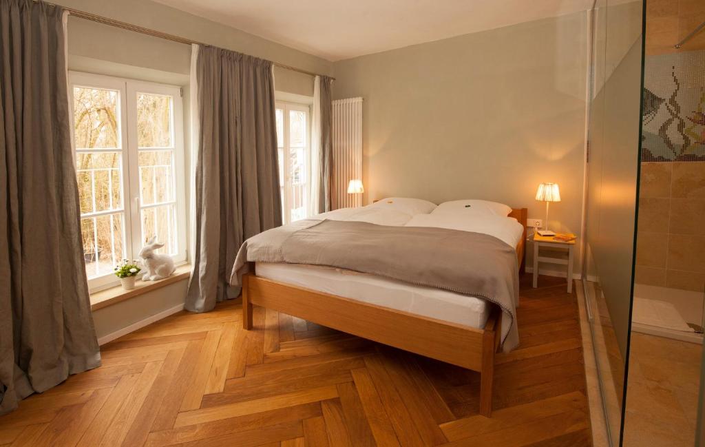 诺德林根Bed and Breakfast unter den Linden的一间卧室设有一张大床和两个窗户。