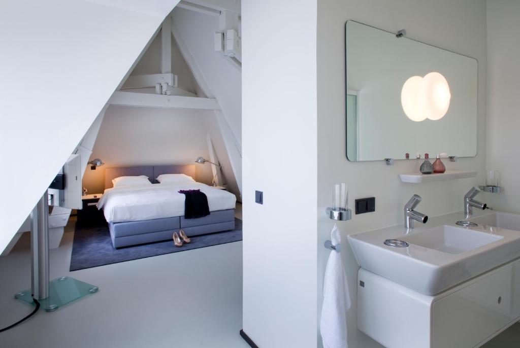 马斯特里赫特城市公寓马斯特里赫特酒店的一间卧室配有床、水槽和镜子